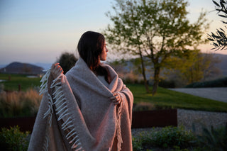 Una ragazza in un giardino, cammina coprendosi con una coperta Cecchi e Cecchi